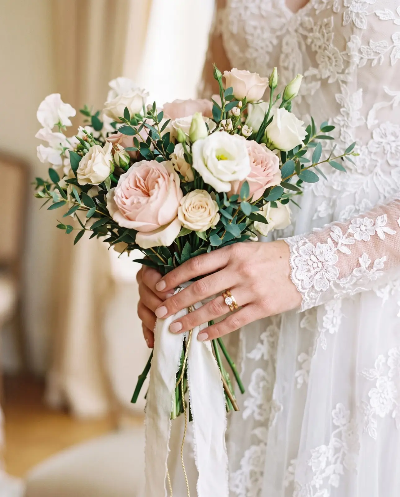 Mani della sposa che stringono il bouquet