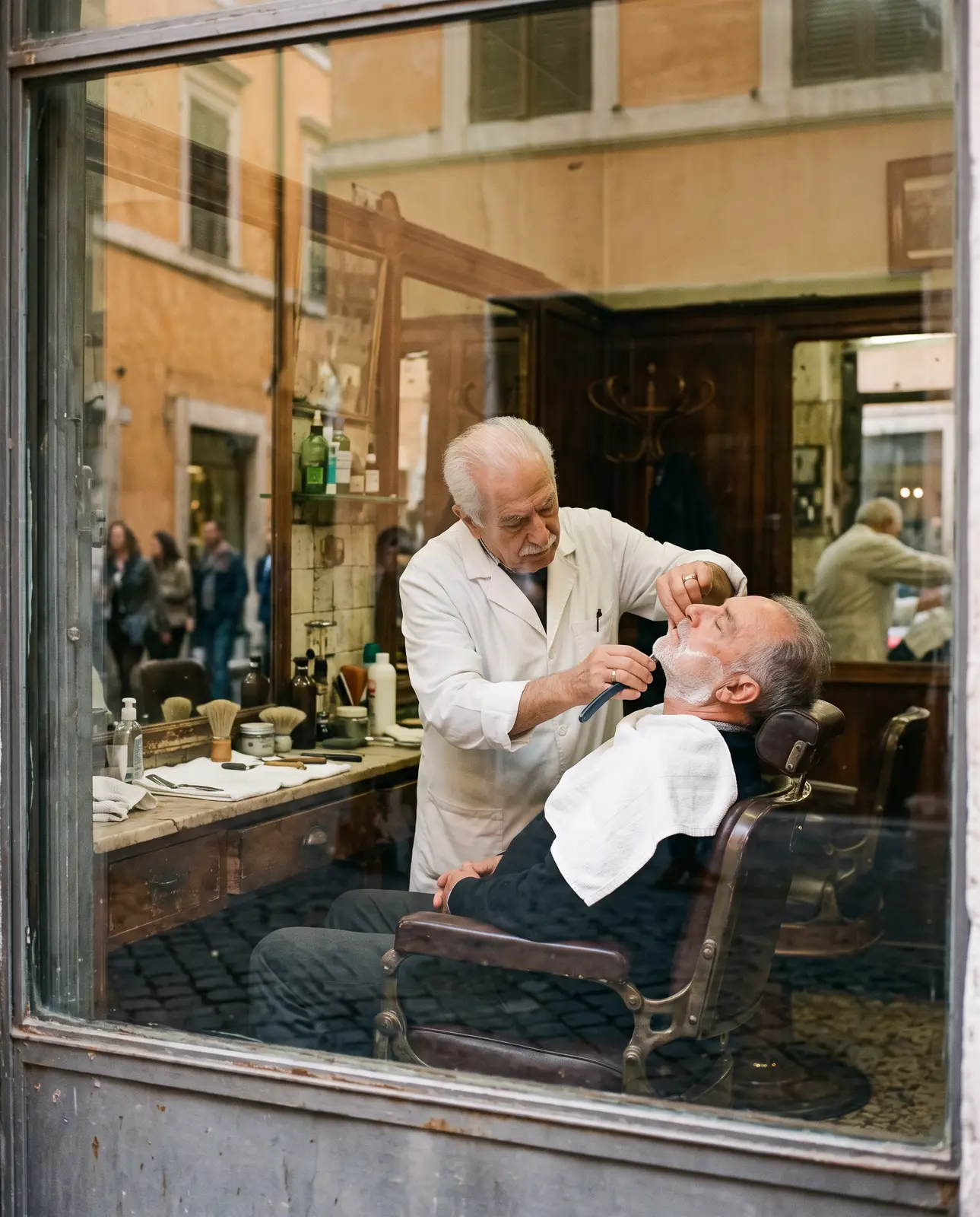 Un barbiere fa la barba a un cliente, visto attraverso la vetrina
