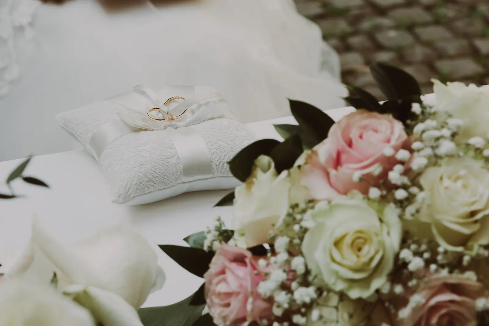 Fedi sul cuscino accanto al bouquet